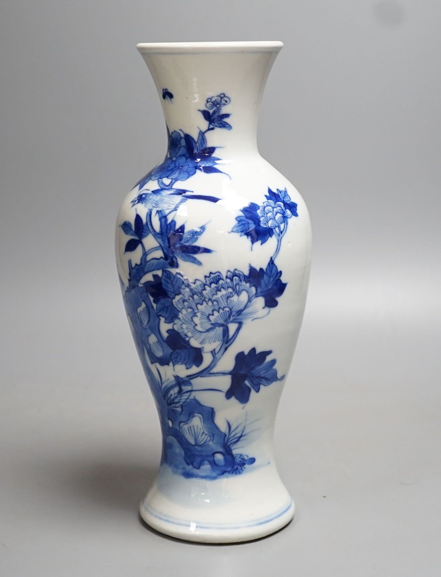 A late 19th century Chinese blue and white baluster vase, painted with birds amid flowers and rock work, pseudo Kangxi mark. 26cm